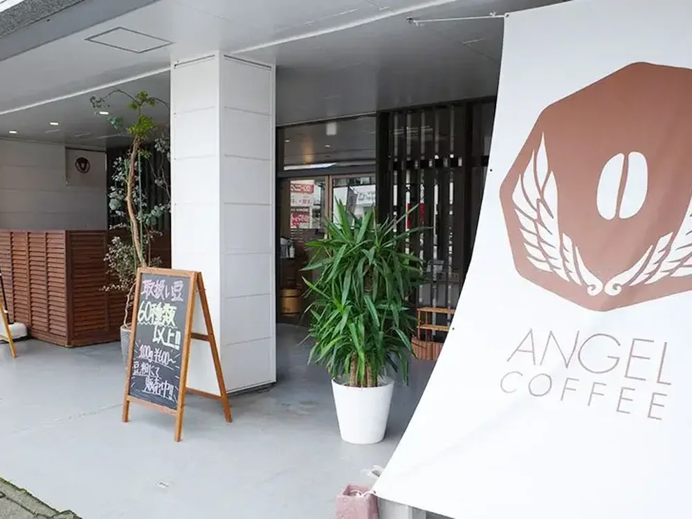 ANGEL COFFEEのロゴ入りタペストリーと黒板が置かれた泉が丘店の入口