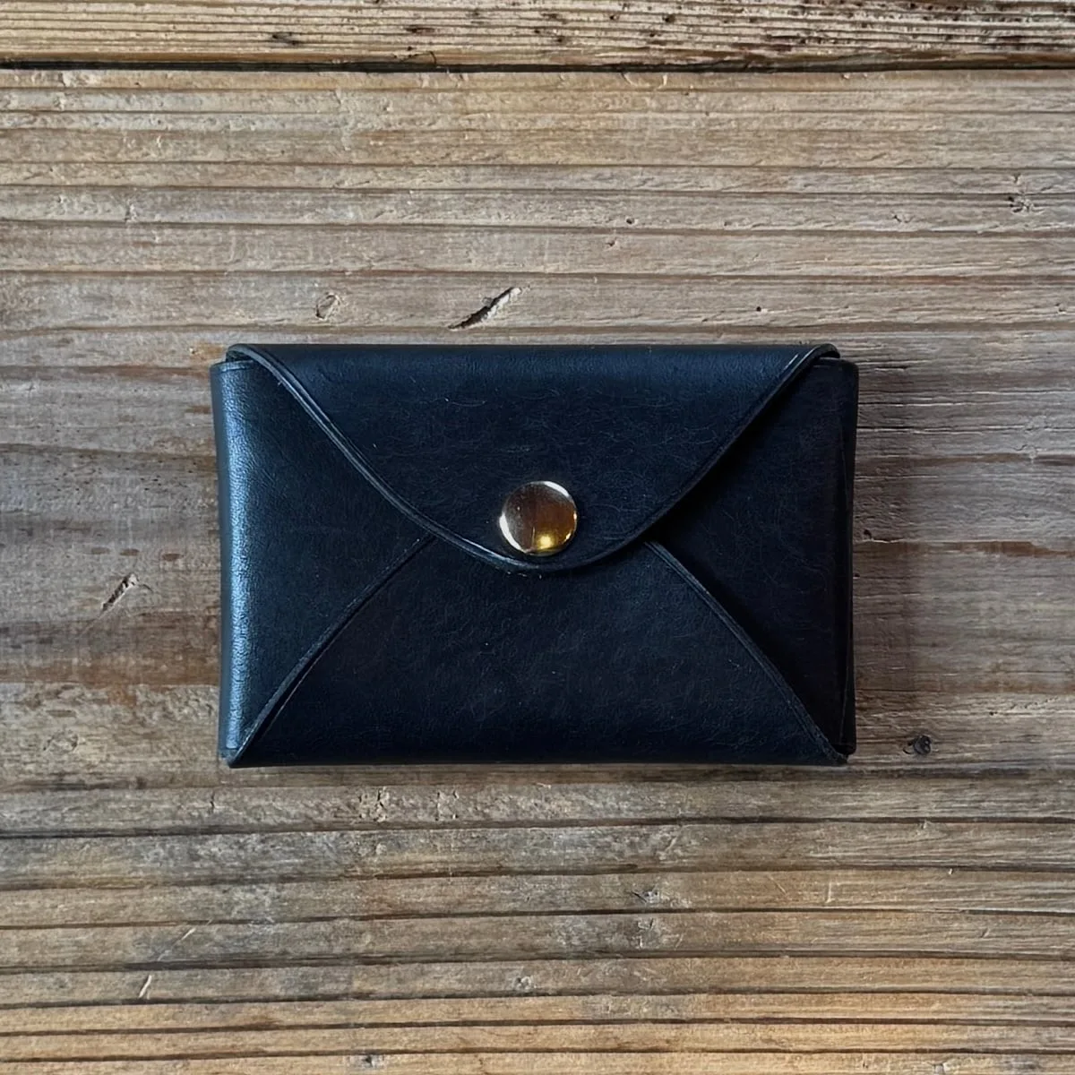 真鍮ホックで閉じた黒い革の名刺入れPatina