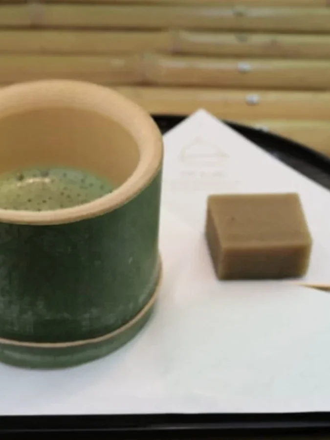 竹の器に入った抹茶と、和菓子のおやつ