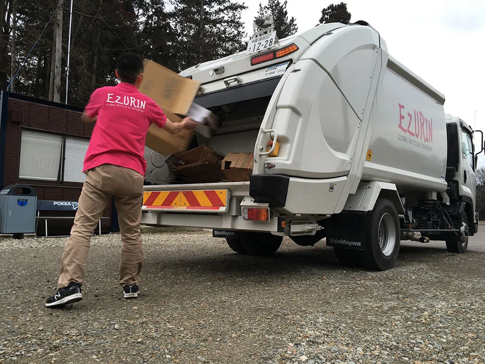 収集車に荷物を積み込むエヅリンのスタッフ