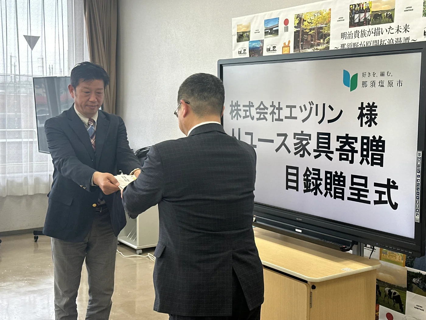 家具寄贈の目録贈呈式で目録を手渡す様子