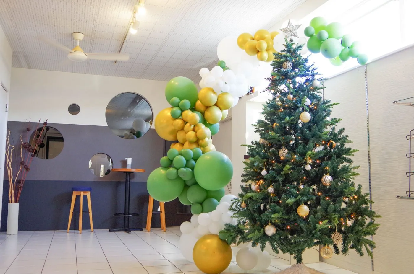 クリスマスツリーと緑や金のバルーンで飾った店内