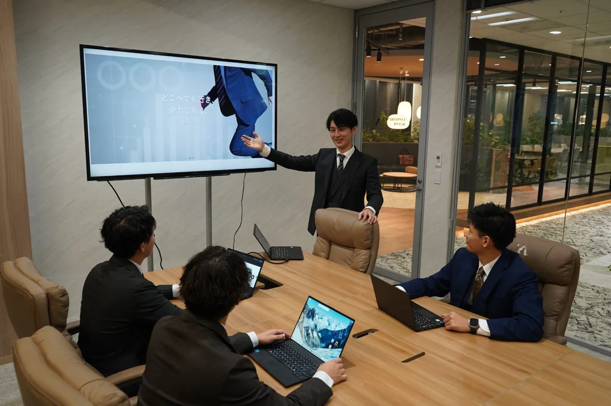 大きな画面に資料を映し、企画を説明する打ち合わせ