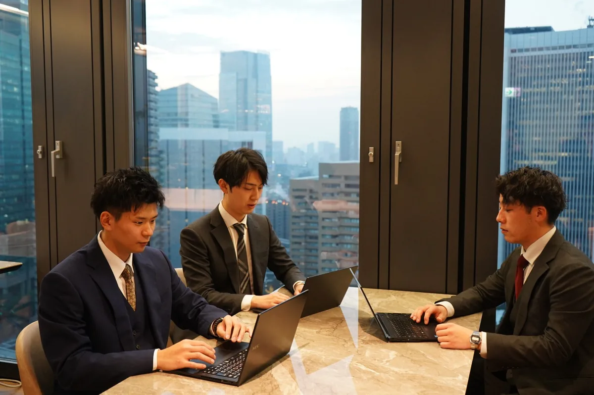 窓際のテーブルでパソコンを開き、打ち合わせをするGo&Doのスタッフ