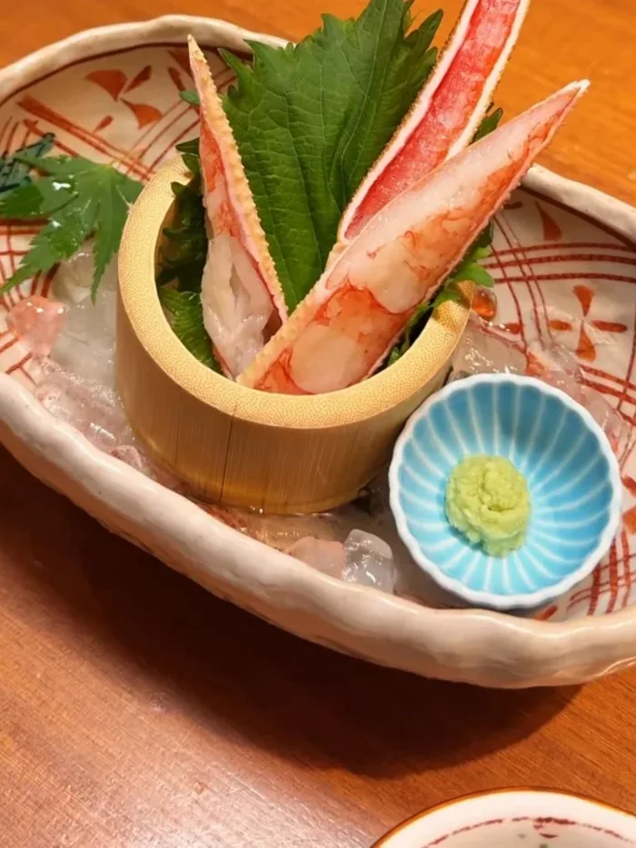 大葉を添えて盛られた、かにの刺身