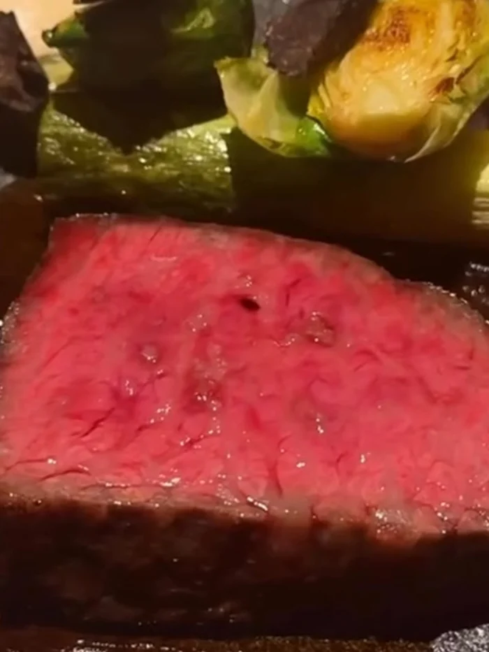 黒い器に盛られた、和牛のロースト