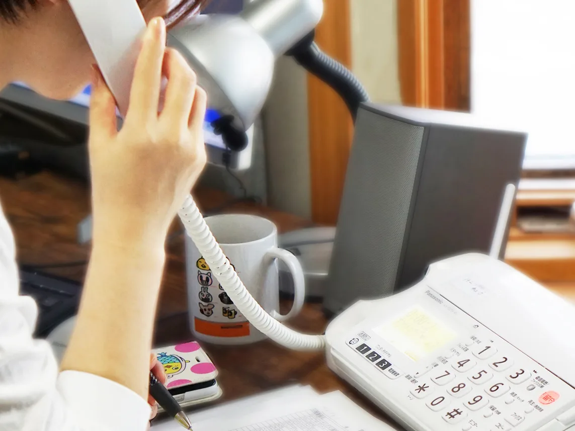 本を手元に置いて、電話で相談を受ける様子