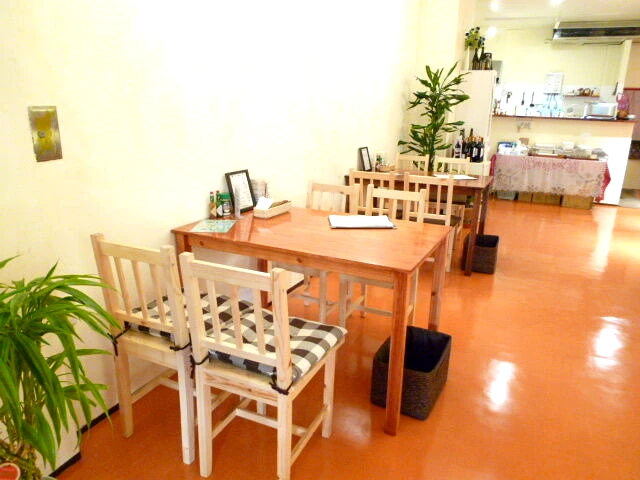 Kitchen KANEYAの店内。木のテーブルと観葉植物が並ぶ明るい空間