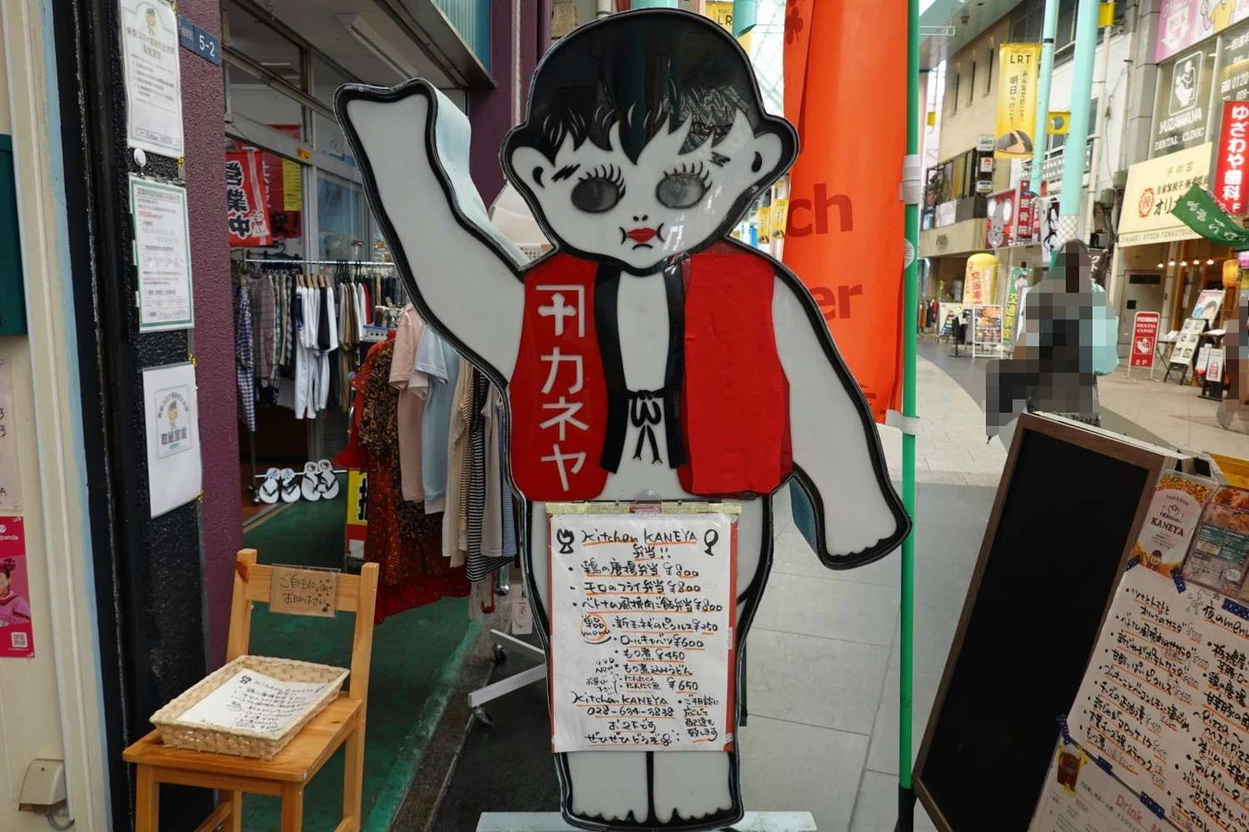オリオン通りに立つ看板「カネ子」と、Kitchen KANEYAの店頭メニュー