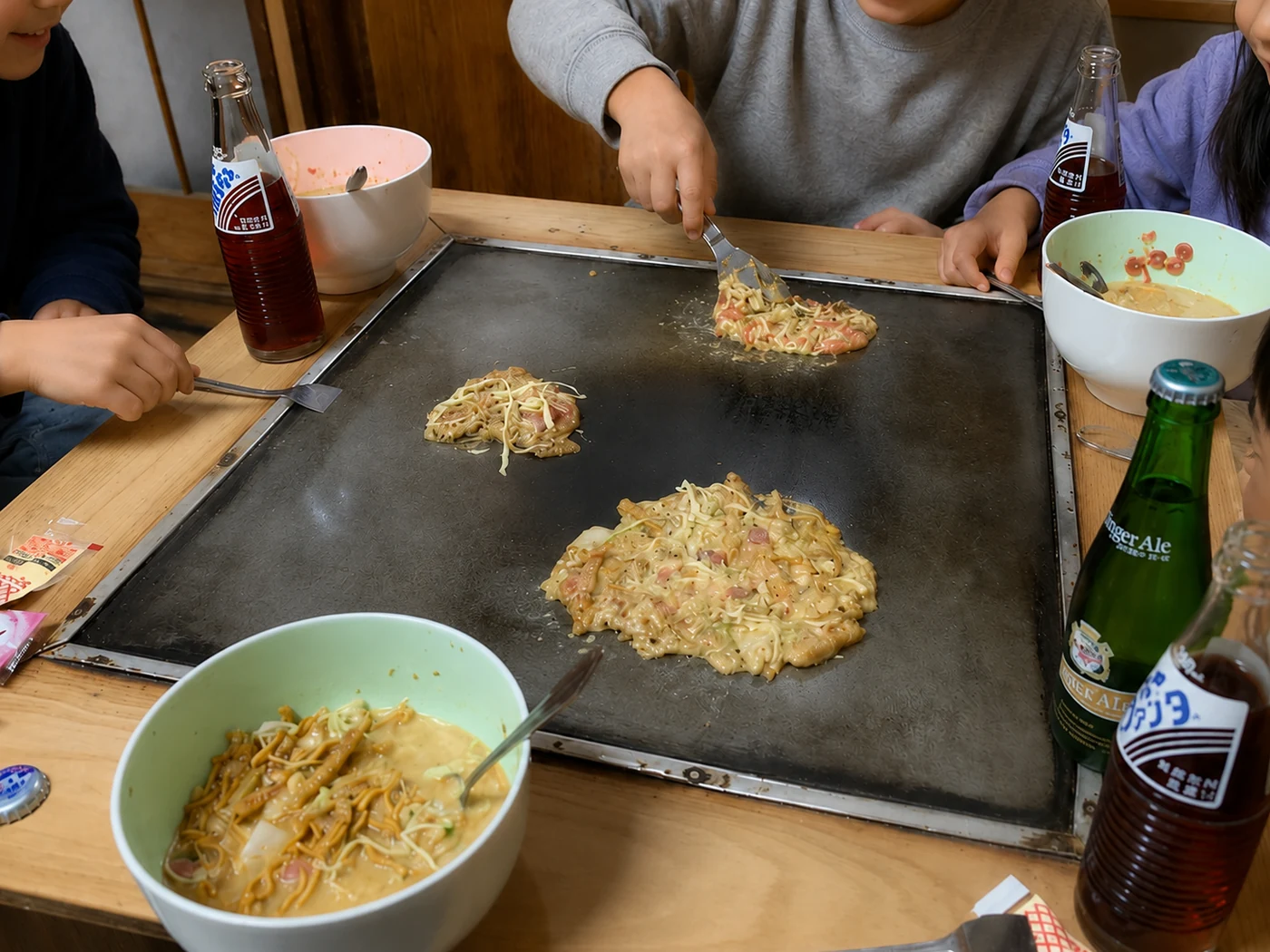 ひとつの鉄板を囲み、それぞれのもんじを焼く子どもたちの手元