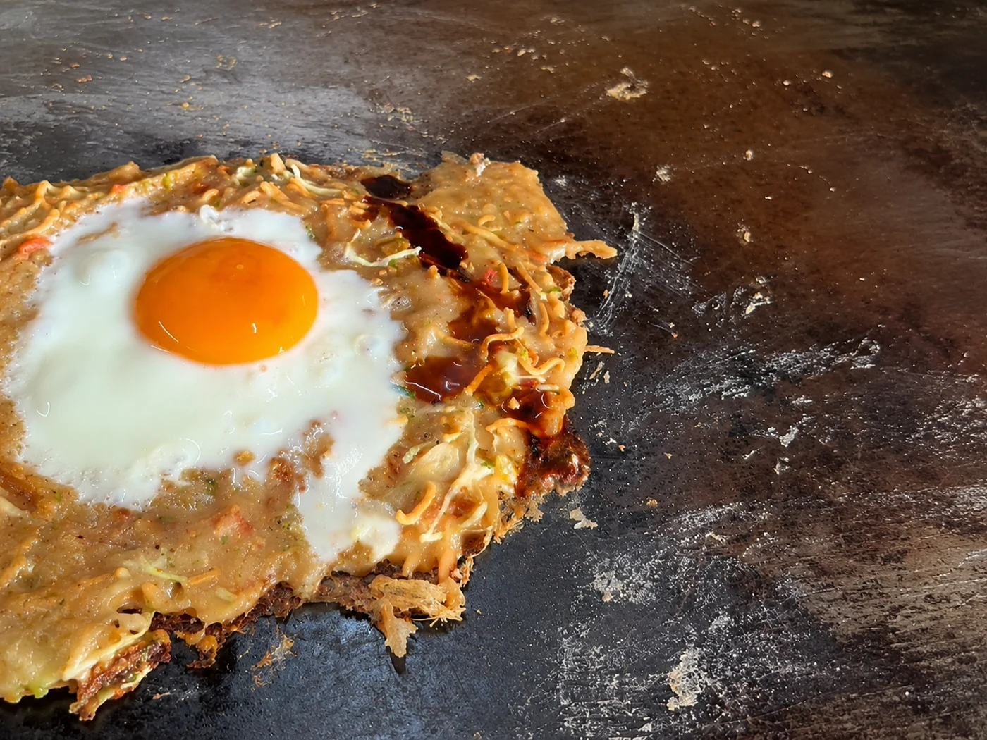 鉄板の上で焼き上がっていく、卵をのせたもんじ