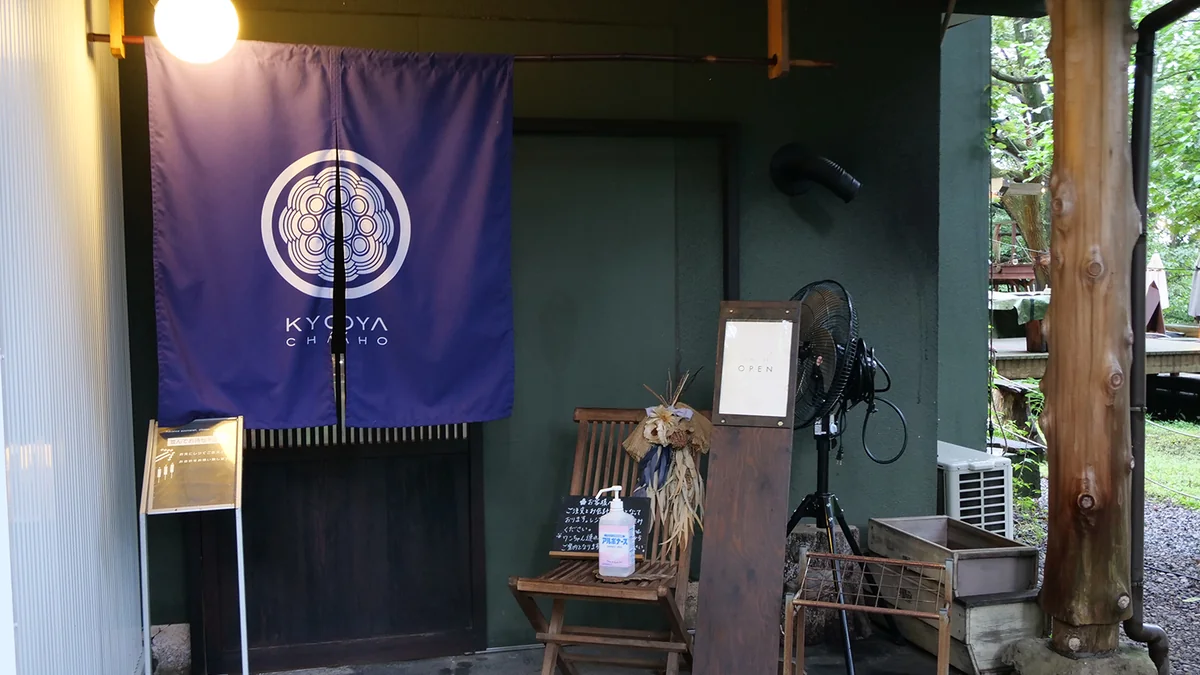 森に面した京屋茶舗の入口と九星の暖簾