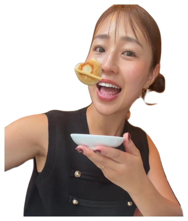 餃子を箸で口に運ぶ、笑顔のまきえ氏