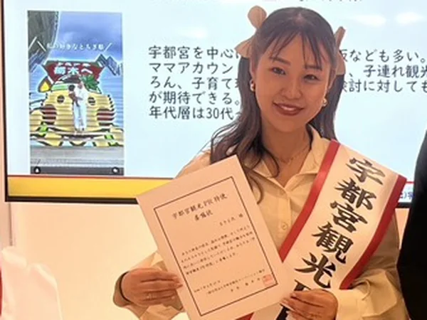 宇都宮観光PR特使のたすきを掛け、委嘱状を手にするまきえ氏