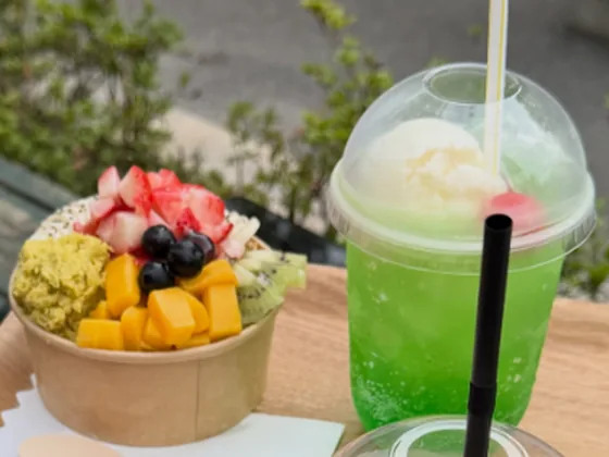 フルーツをのせたカップのスイーツと、アイスをのせたメロンソーダ