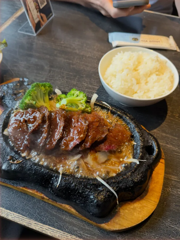 鉄板で音を立てるステーキと、白いごはん