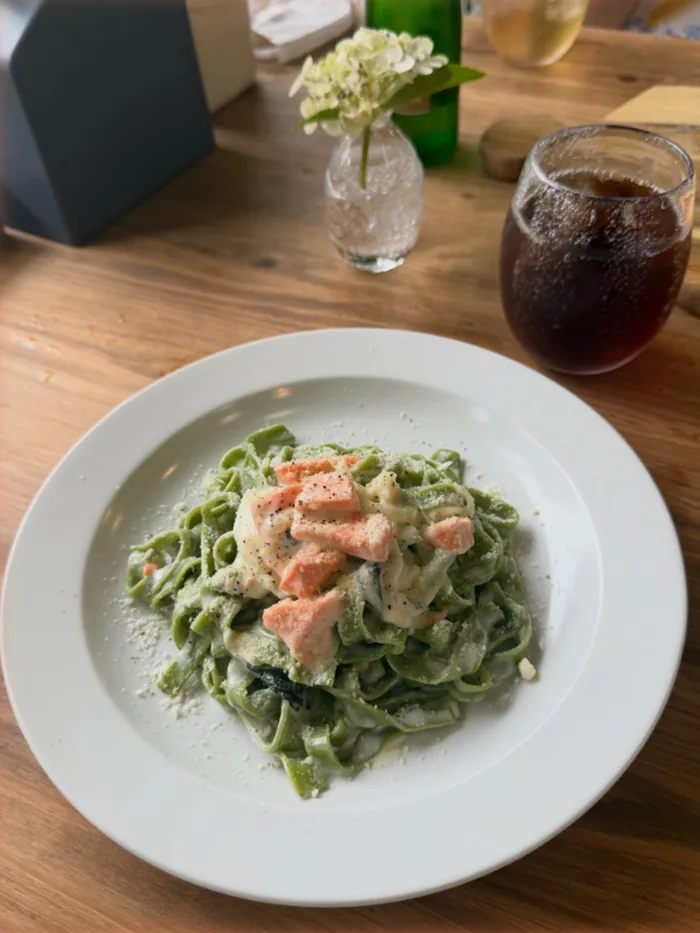 サーモンのクリームソースをからめた、緑色の平打ちパスタ