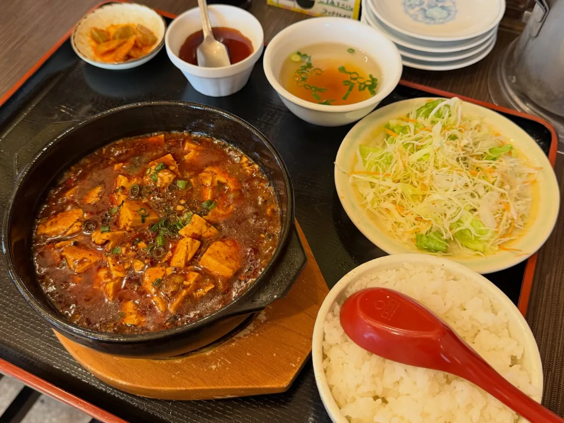 石焼きの器で煮立つ麻婆豆腐と、ごはん、サラダ、スープ、ザーサイの定食