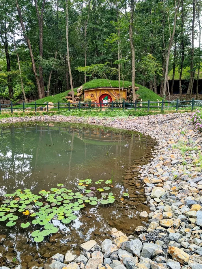 森の中の池と、草屋根の小屋