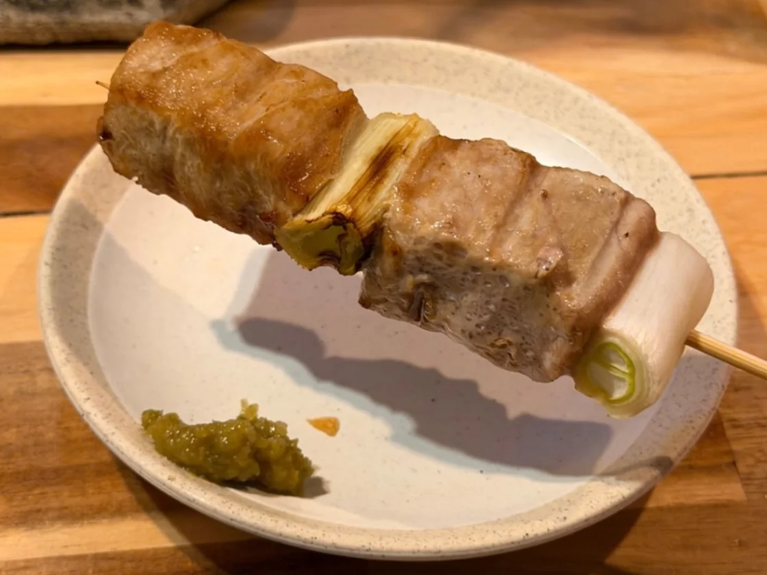 小皿にのせた、まぐろとねぎを交互に刺した串焼き