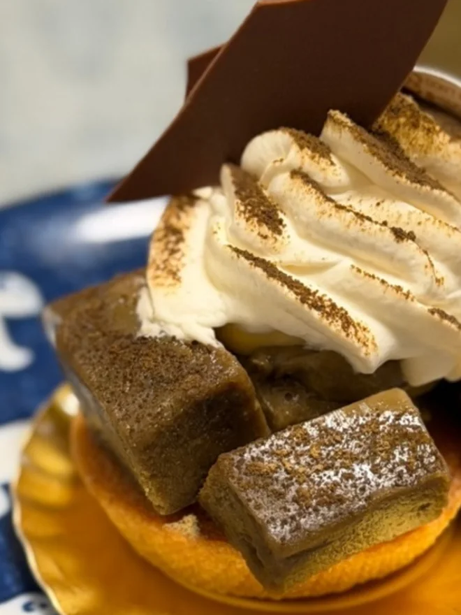 チョコレートの飾りと絞ったクリームをのせた、焼き菓子のケーキ