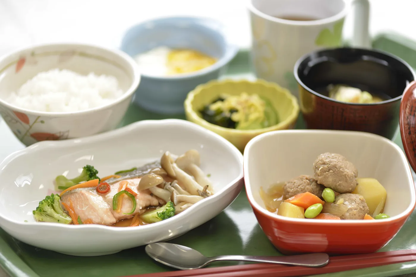 施設で提供する一食。ご飯、魚の煮付け、肉団子、和え物、汁物