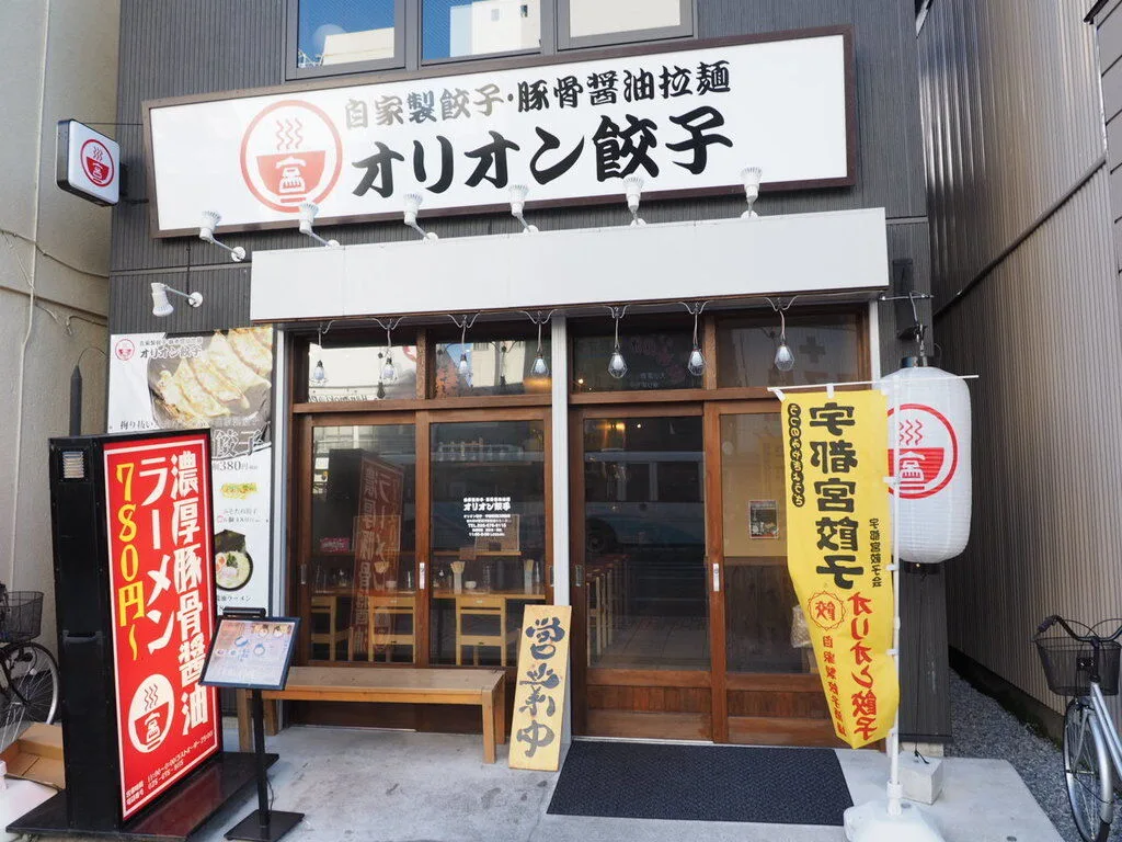 自家製餃子・豚骨醤油拉麺の看板を掲げるオリオン餃子の店舗外観