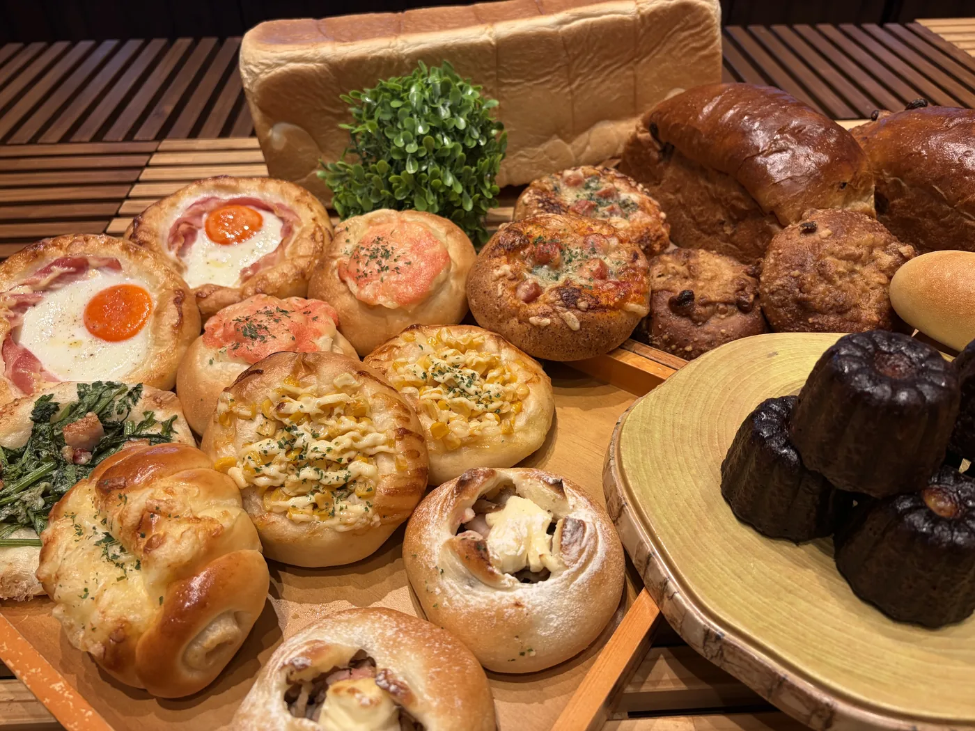 総菜パンや甘いパン、食パンなど、さまざまなパンを並べたもの