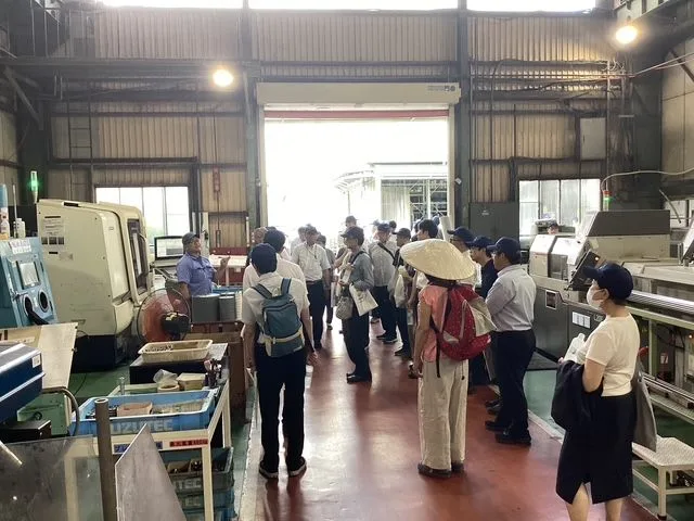 工場見学に訪れたお客様に、製造の現場を案内する様子