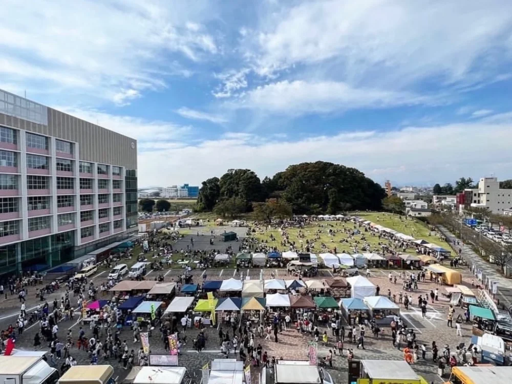 青空の下、たくさんのテントと人でにぎわう屋外イベントの会場
