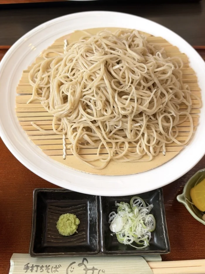 白い器に盛られた、細くて艶のある手打ちそば