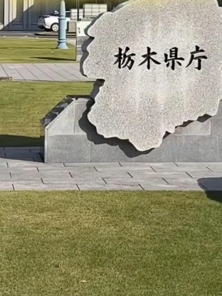 栃木県庁前の芝生と、栃木県の形をした庁舎の銘板