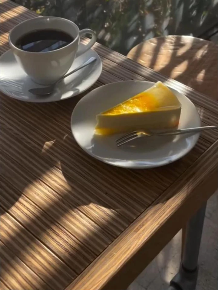 日差しの入るテーブルに置かれた、コーヒーとケーキ