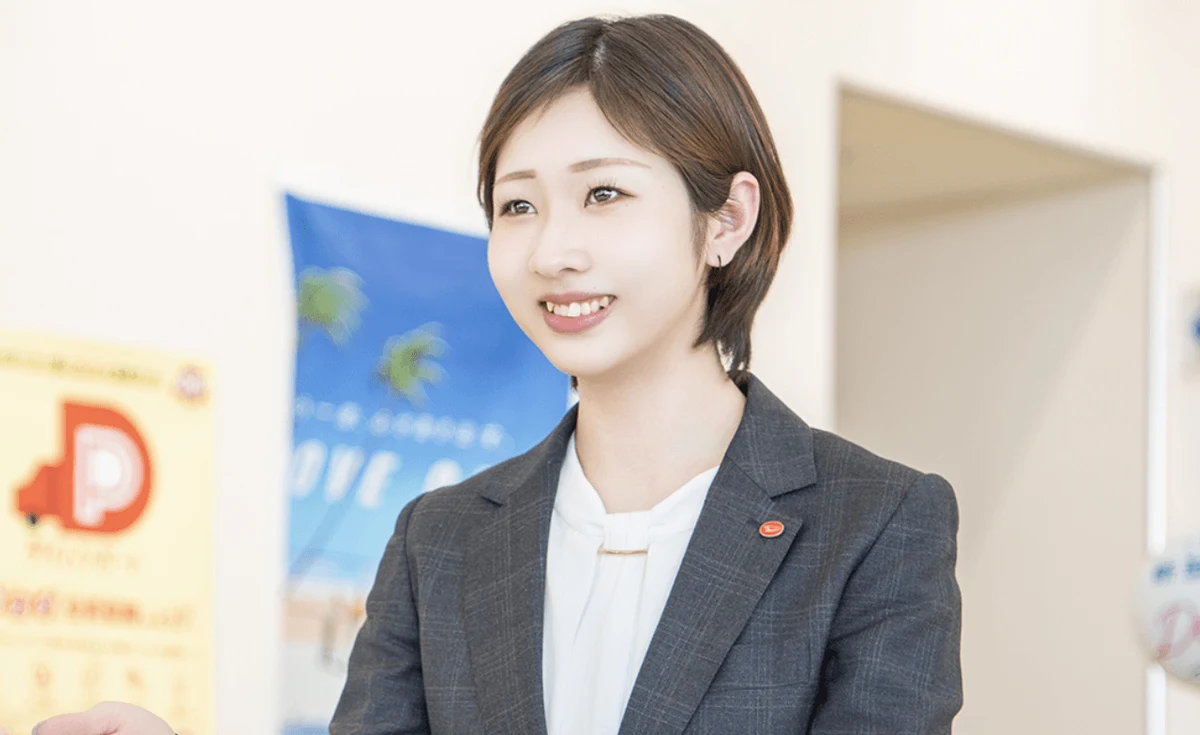 店舗で来店者に笑顔で説明する栃木ダイハツのスタッフ