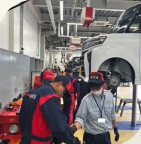 車両を前に実務研修を受ける新人整備スタッフ
