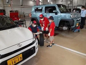 整備工場でタイヤの溝を測る子どもたち