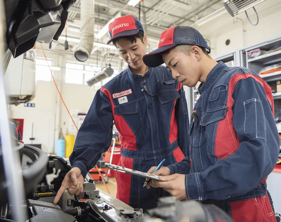 車両を前に作業を確認する整備スタッフたち