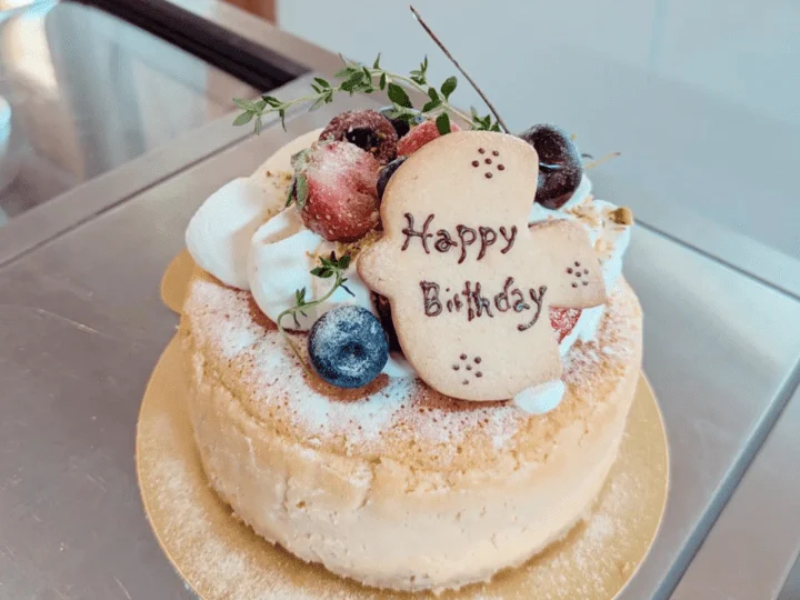 Happy Birthdayのクッキープレートといちごを飾った、生クリームのデコレーションケーキ