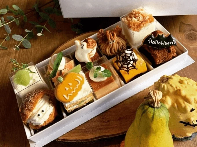 かぼちゃやおばけの飾りをのせた小さなケーキが、白い箱に詰め合わされた様子