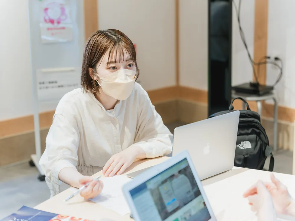 ノートパソコンを前に、資料を手に相談する参加者
