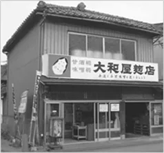 「大和屋商店」の看板を掲げた、かつての店構えのモノクロ写真