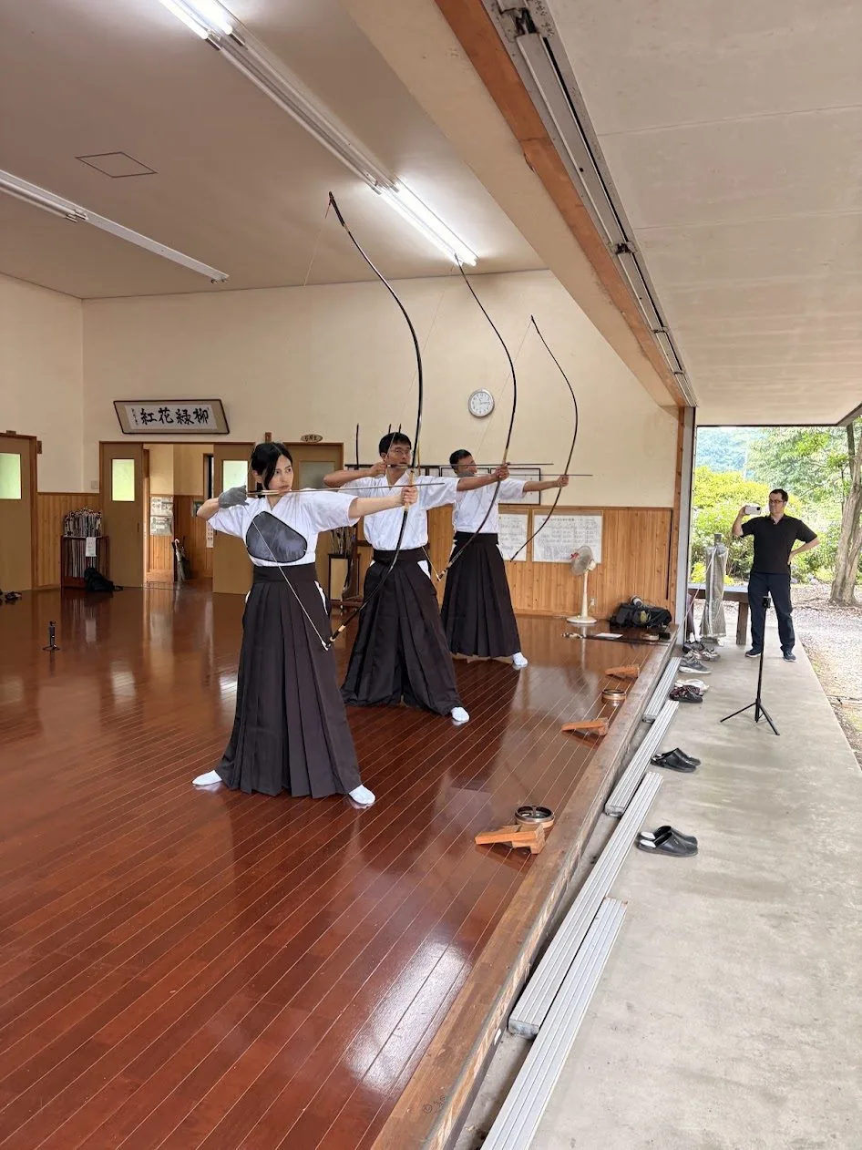 弓道場で的に向かって弓を引く台湾からの参加者