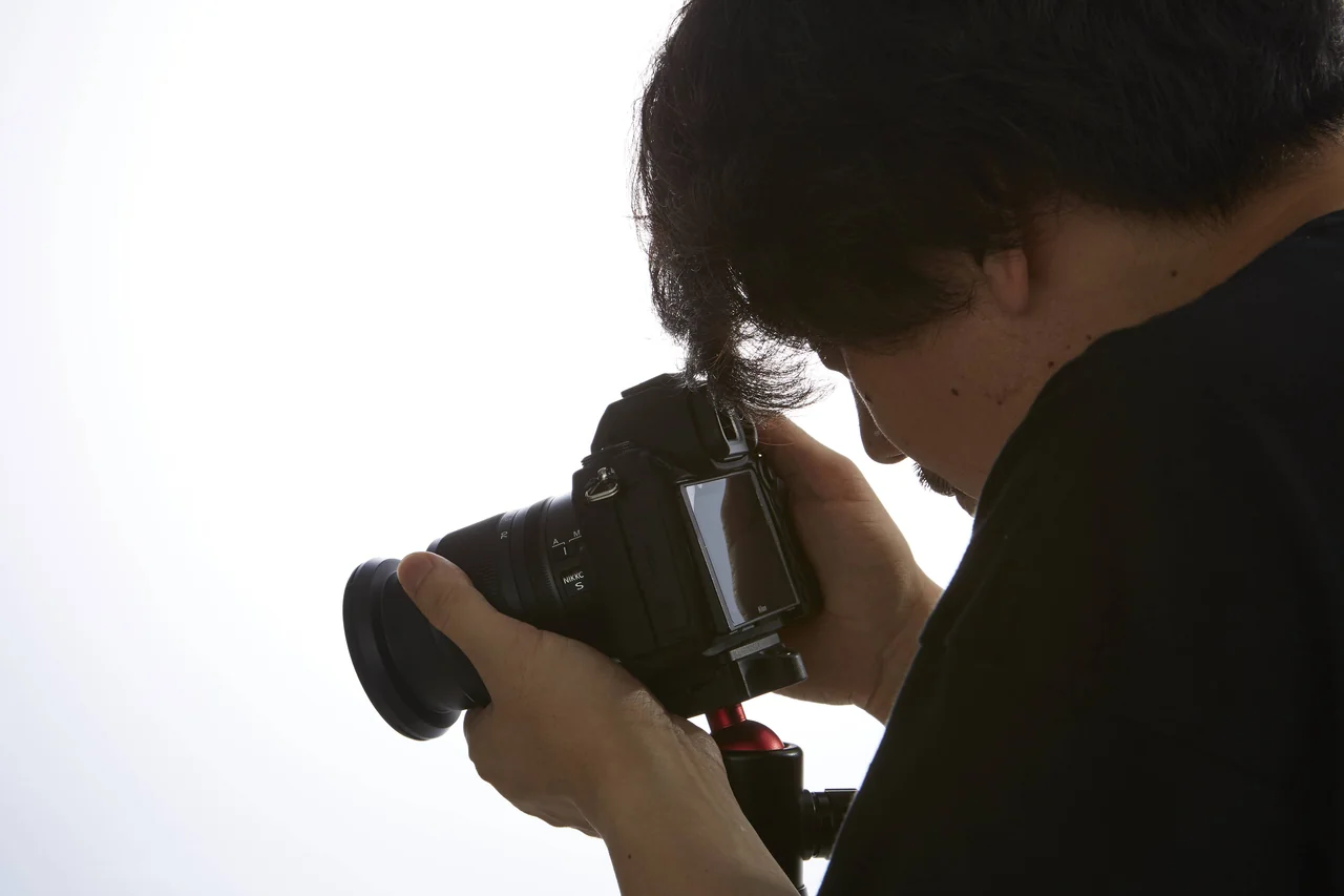 カメラのファインダーをのぞいて撮影するスタッフ