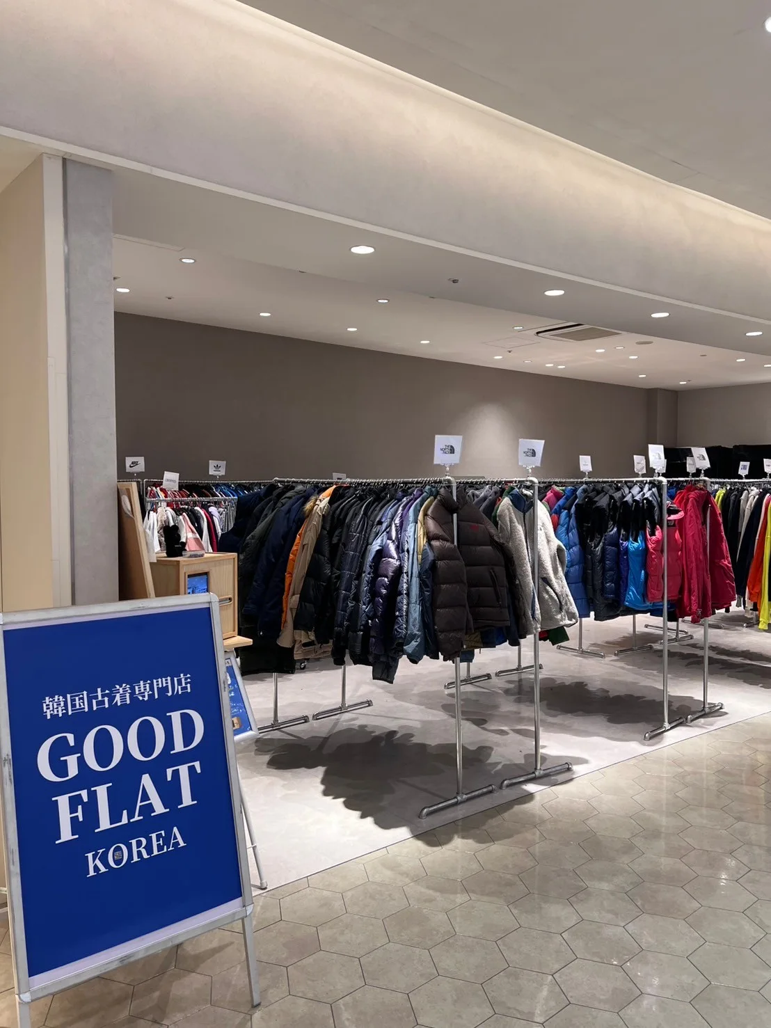 GOODFLAT-KOREA-の看板と古着が並ぶ売場